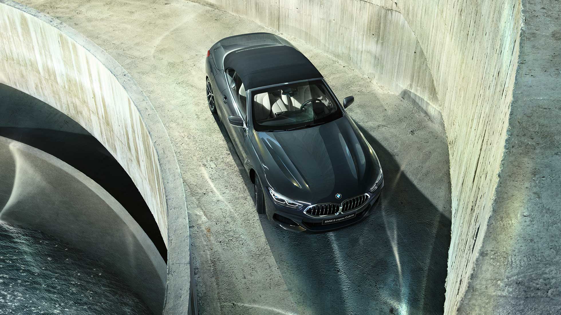 BMW M850i xDrive, металлик Серый Дравит, с мягким верхом черного цвета, вид с высоты птичьего полета. BMW M850i xDrive, металлик Серый Дравит, с мягким верхом черного цвета, вид с высоты птичьего полета.